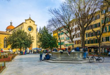 FLORENCE, ITALY, 15 Mart 2016: İtalya 'nın Floransa kentindeki Santo Spirito kilisesinin önündeki çeşmede oturan bir grup genç insan.