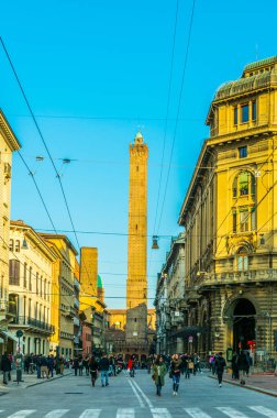 BOLOGNA, ITALY, 17 Mart 2016: İnsanlar Franco Rizzoli üzerinden Bologna 'nın iki kulesine doğru yürüyor - Torre Garisenda ve Torre Degli Asinelli