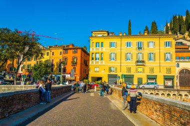 VERONA, İtalya, 19 Mart 2016: Turistler Verona, İtalya 'daki Ponte Pietra Köprüsü' nden geçiyorlar