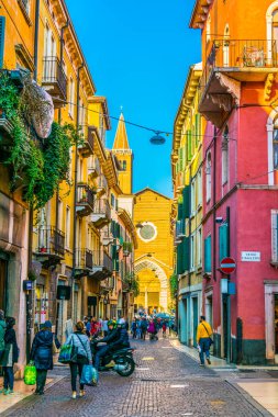 VERONA, İtalya, 19 Mart 2016: İnsanlar Verona, İtalya 'daki Dominik Santa Anastasia Kilisesi' ne doğru dar bir sokakta geziniyor