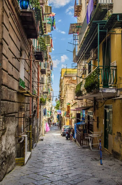 NAPLES, ITALY, HAZİRAN 24, 2014: İnsanlar İtalya Napoli 'deki tarihi eski şehrin dar sokaklarından geçiyor.