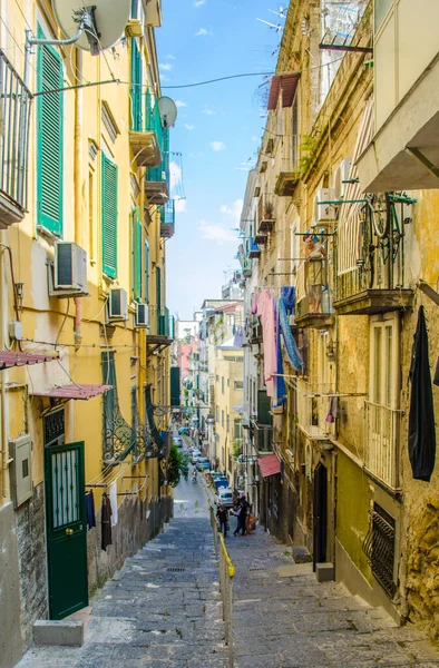 NAPLES, ITALY, HAZİRAN 24, 2014: İnsanlar İtalya Napoli 'deki tarihi eski şehrin dar sokaklarından geçiyor.