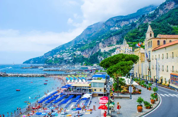 AMALFI, İtalya - 28 Haziran 2014: İnsanlar İtalya 'nın Amalfi kentinin pitoresk yaz manzarasının tadını çıkarıyorlar. Amalfi UNESCO Dünya Mirası Alanlarına dahil edildi.