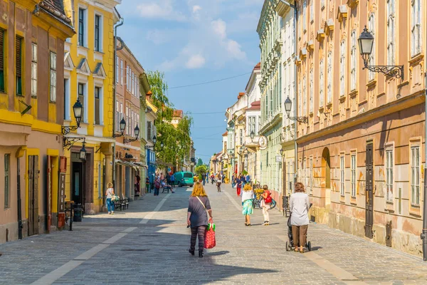 GYOR, HUNGARY 20 Mayıs 2016: Macaristan 'ın eski kentinde insanlar dar bir sokakta yürüyorlar.