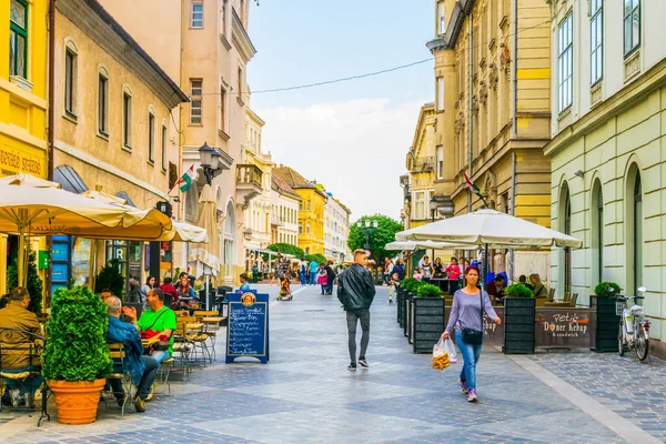 GYOR, HUNGARY 20 Mayıs 2016: Macaristan 'ın eski kentinde insanlar dar bir sokakta yürüyorlar.