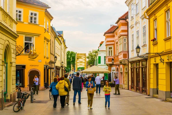 GYOR, HUNGARY 20 Mayıs 2016: Macaristan 'ın eski kentinde insanlar dar bir sokakta yürüyorlar.