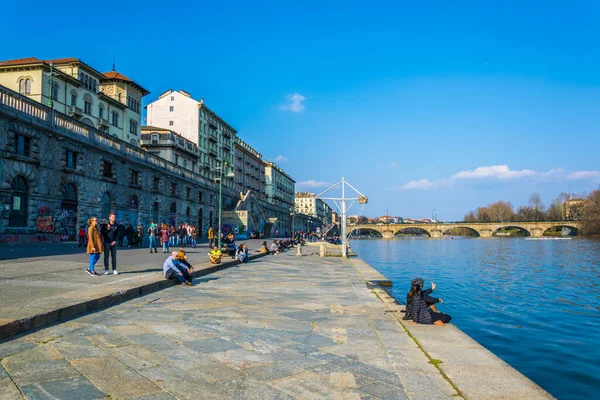 TORINO, İtalya, 12 Mart 2016: İtalya 'nın Torino şehrinde insanlar Po Nehri' nin Murazzi nehri kenarında yürüyorlar.