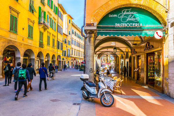 ПИСА, ИТАЛИЯ, 14 марта 2016 года: люди наслаждаются солнечным днем на весенней прогулке по виа Гульельмо в городе Пиза..