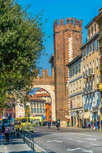 VERONA, ITALY, MARCH 19, 2016: İnsanlar Mart ayında güneşli bir günde Verona 'daki ana meydanın başlangıcını gösteren tuğla kemer işaretli Corso porta nuova' ya doğru yürüyorlar