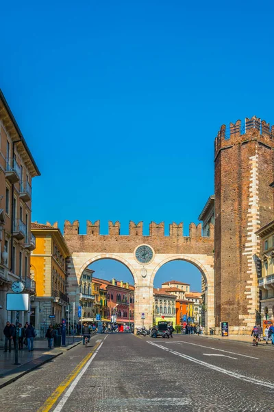 VERONA, ITALY, MARCH 19, 2016: İnsanlar Mart ayında güneşli bir günde Verona 'daki ana meydanın başlangıcını gösteren tuğla kemer işaretli Corso porta nuova' ya doğru yürüyorlar