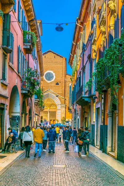 VERONA, İtalya, 19 Mart 2016: İnsanlar Verona, İtalya 'daki Dominik Santa Anastasia Kilisesi' ne doğru dar bir sokakta geziniyor
