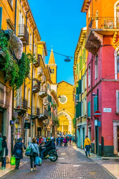 VERONA, İtalya, 19 Mart 2016: İnsanlar Verona, İtalya 'daki Dominik Santa Anastasia Kilisesi' ne doğru dar bir sokakta geziniyor