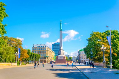 RIGA, LATVIA, 15 Ağustos 2016: Riga, Letonya 'daki Özgürlük Anıtı' nın yanında yürüyen insanlar.