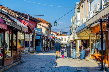 ÜSKÜP, MACEDONIA, FEBRUARY 16, 2015: İnsanlar mağazalar, restoranlar ve hatta pazar yerleriyle dolu çok sayıda dar sokaktan oluşan eski Skopje kasabasında yürüyorlar.