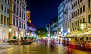 MÜZİK, GERMANY, 20 AĞUSTOS 2015: İnsanlar Münih 'teki Karlsplatz Kapısı' na doğru aydınlanmış Neuhauser Caddesi 'nde yürüyorlar.