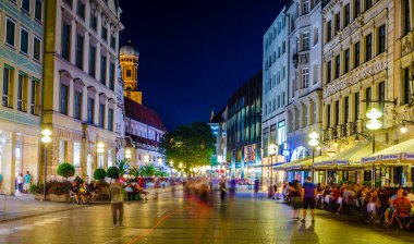 MÜZİK, GERMANY, 20 AĞUSTOS 2015: İnsanlar Münih 'teki Karlsplatz Kapısı' na doğru aydınlanmış Neuhauser Caddesi 'nde yürüyorlar.