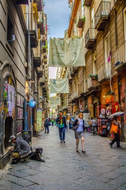 NAPLES, ITALY, MAY 8, 2014: People are passing by through narrow streets of historical old town in italian naples.