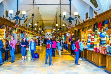 KRAKOW, POLAND, HAZİRAN 11 AĞUSTOS 2016: Krakow, Polonya 'daki Sukiennice Pazar Salonu' ndaki (Kumaş Salonu, Drapers 'Hall) dükkanlar arasında gezinen insanlar