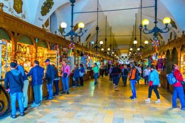 KRAKOW, POLAND, AUGUST 11, 2016: People are strolling among shops inside of the Sukiennice marketplace (Cloth Hall, Drapers' Hall) in Krakow (Cracow), Poland