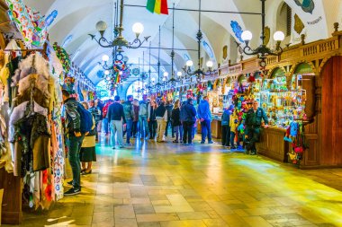 KRAKOW, POLAND, HAZİRAN 11 AĞUSTOS 2016: Krakow, Polonya 'daki Sukiennice Pazar Salonu' ndaki (Kumaş Salonu, Drapers 'Hall) dükkanlar arasında gezinen insanlar
