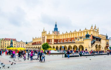 KRAKOW, POLAND, AUGUST 11, 2016: People are strolling in front of the Sukiennice marketplace (Cloth Hall, Drapers' Hall) in Krakow (Cracow), Poland