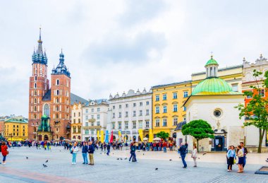 KRAKOW, POLAND, HAZİRAN 11 AĞUSTOS 2016: St. Mary Kilisesi ve Krakow / Krakow kentindeki Saint Adalbert Kilisesi 'nin bulunduğu Rynek parlayan ana meydanı panoraması.