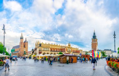 KRAKOW, POLAND, HAZİRAN 11 AĞUSTOS 2016: Polonya 'nın Krakow / Krakow kentindeki Saint Mary kilisesi ve sukiennice pazar yeri ile Rynek parlayan ana meydanının panoraması.