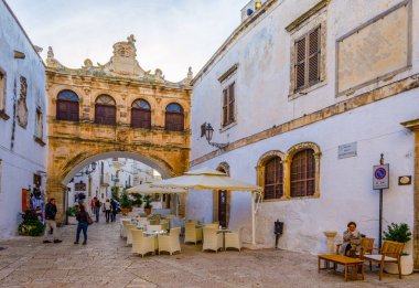 OSTUNI, İtalya, 2 Mayıs 2014: İtalyan kenti ostuni 'de beyaz dar bir caddenin görüntüsü