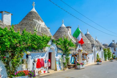 ALBEROBELLO, ITALY, JUNE 21, 2014: Tourists are enjoying sunny day among trulli houses in Alberobello, Italy.