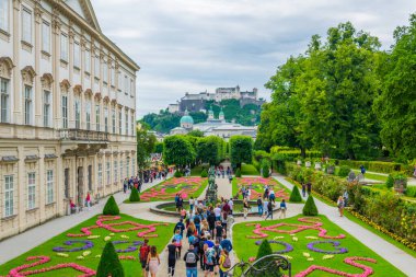 SALZBURG, AUSTRIA, 3 Temmuz 2016: İnsanlar Salzburg, Avusturya 'daki tarihi Hohensalzburg Kalesi' nin arka planında Mirabell Bahçeleri 'nde geziniyorlar