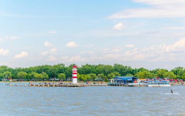 PODERSDORF, AUSTRIA, 9 Temmuz 2016: Gençler Podersdorf am 'da ünlü kırmızı ve beyaz deniz fenerinin yakınında uçurtma sörfü yapıyorlar..