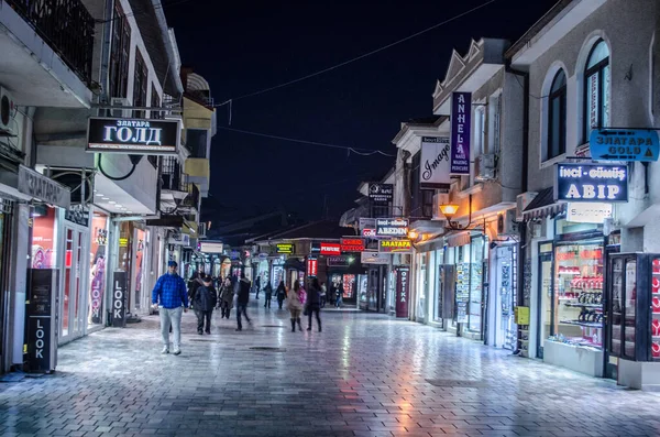OHRID, MACEDONIA, FEBRUARY 14, 2015: Unesco listelenmiş tarihsel Macar kasabasının merkezindeki aydınlatılmış ana alışveriş yolu üzerinde gece görüşü.