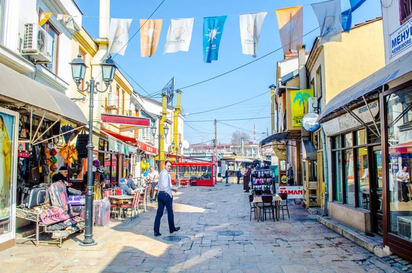 ÜSKÜP, MACEDONIA, FEBRUARY 16, 2015: İnsanlar mağazalar, restoranlar ve hatta pazar yerleriyle dolu çok sayıda dar sokaktan oluşan eski Skopje kasabasında yürüyorlar.