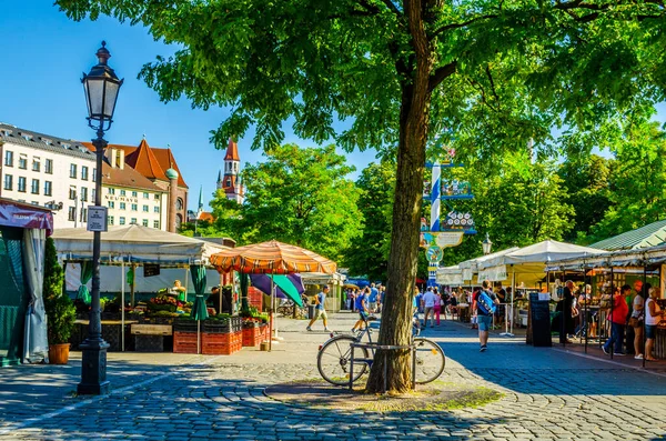 Münih, Germamy 'deki Viktualienmarkt' taki insanlar. Bu geleneksel pazar 1807 'den beri her gün gerçekleşir. .