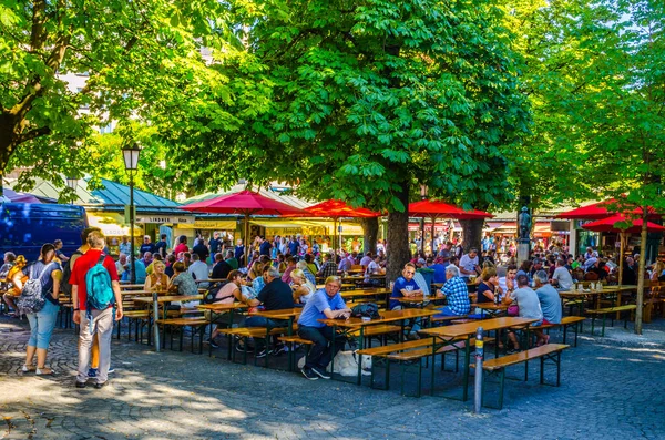 Münih, Germamy 'deki Viktualienmarkt' taki insanlar. Bu geleneksel pazar 1807 'den beri her gün gerçekleşir. .