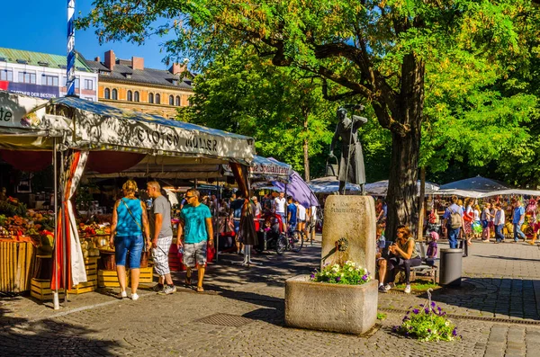 Münih, Germamy 'deki Viktualienmarkt' taki insanlar. Bu geleneksel pazar 1807 'den beri her gün gerçekleşir. .