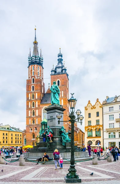 KRAKOW, POLAND, 11 AĞUSTOS 2016: Polonya 'nın Krakow / Krakow kentindeki Aziz Mary Kilisesi' nin önünden insanlar geçiyor.