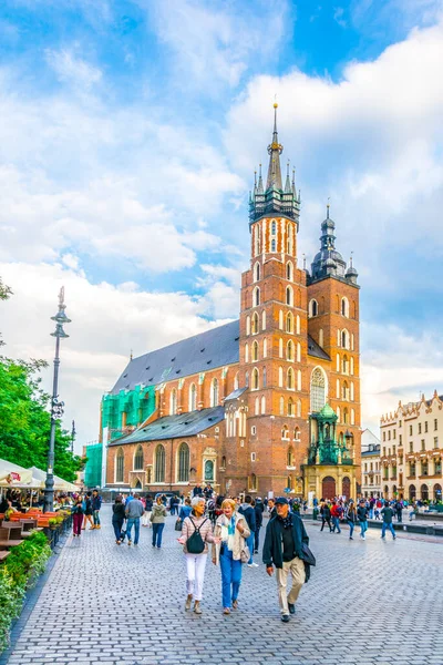 KRAKOW, POLAND, 11 AĞUSTOS 2016: Polonya 'nın Krakow / Krakow kentindeki Aziz Mary Kilisesi' nin önünden insanlar geçiyor.