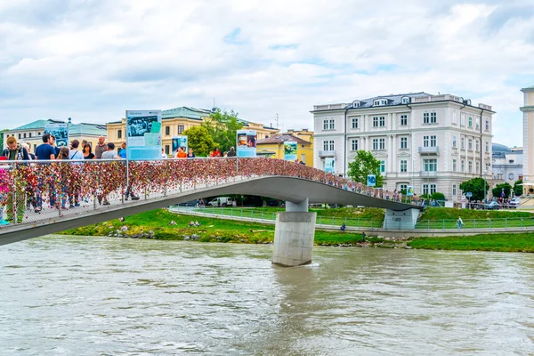 SALZBURG, AUSTRIA, 3 Temmuz 2016: İnsanlar Salzburg 'daki Salzach nehrinin kıyılarını birbirine bağlayan Mullner steg köprüsünü geçiyor.