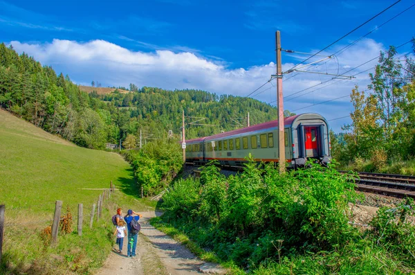 SEMERING, AUSTRIA, 3 ECTOBER 2015: Bir tren Avusturya 'daki semmeringbahntrail' de yürüyüş yapan bir ailenin yanından geçiyor