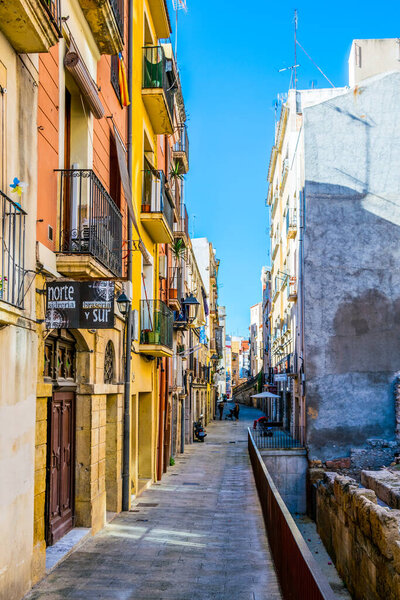 TARRAGONA, SPAIN, DECEMBER 29, 2015: people are strolling through a colorful narrow street in the historical center of spanish city tarragona