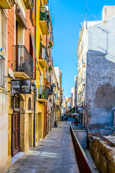 TARRAGONA, SPAIN, DECEMBER 29, 2015: people are strolling through a colorful narrow street in the historical center of spanish city tarragona