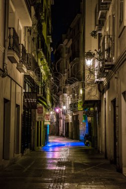 VALENCIA, SPAIN, DECEMBER 31, 2015: people are walking through a narrow street in the old town center of spanish city valencia.