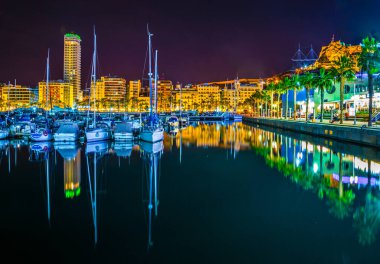 ALICANTE, SPAIN, 2 HAZİRAN 2016: İspanya 'nın Alicante kentindeki aydınlık rıhtımın gece manzarası, bir taraftan marina, diğer taraftan restoran ve barların kemeri ile çevrili.