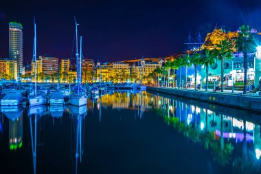 ALICANTE, SPAIN, 2 HAZİRAN 2016: İspanya 'nın Alicante kentindeki aydınlık rıhtımın gece manzarası, bir taraftan marina, diğer taraftan restoran ve barların kemeri ile çevrili.