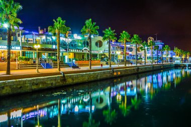 ALICANTE, SPAIN, 2 HAZİRAN 2016: İspanya 'nın Alicante kentindeki aydınlık rıhtımın gece manzarası, bir taraftan marina, diğer taraftan restoran ve barların kemeri ile çevrili.
