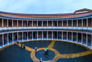 Granada, İspanya, Alhambra 'daki Charles V Sarayı' nda (Palacio de Carlos V) insanlar bir avlunun üzerinde yürüyorlar..