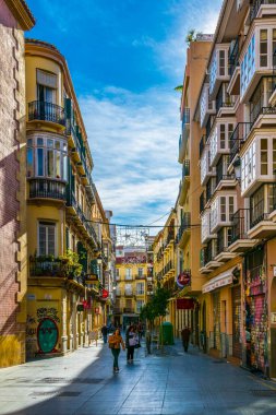 MALAGA, SPAIN, JANUARY 4, 2016: Malaga 'nın tarihi merkezinde turist kalabalığının restoran veya bar aradığı dar bir sokak manzarası.