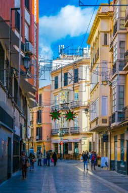 MALAGA, SPAIN, JANUARY 4, 2016: Malaga 'nın tarihi merkezinde turist kalabalığının restoran veya bar aradığı dar bir sokak manzarası.