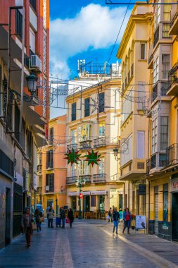 MALAGA, SPAIN, JANUARY 4, 2016: Malaga 'nın tarihi merkezinde turist kalabalığının restoran veya bar aradığı dar bir sokak manzarası.